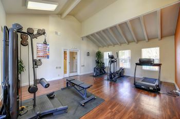 Fitness Center with Elliptical, Excercise Bike, Treadmill, Windows and Hardwood Inspired Floors at Pinecrest Apartments, Davis, CA